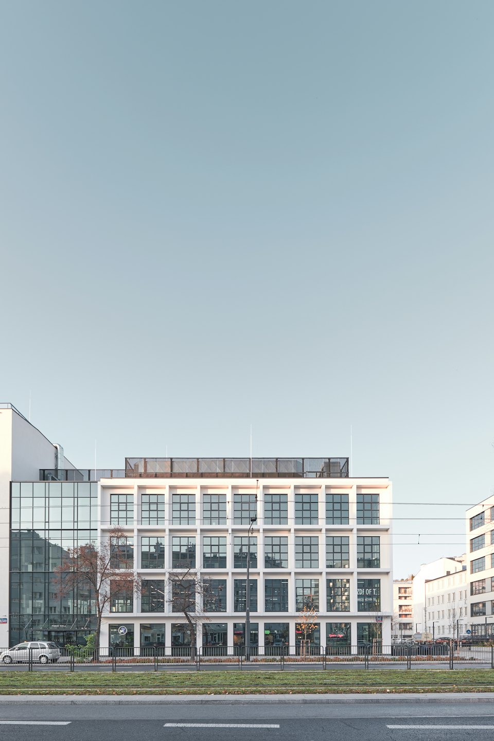 Modernes weißes Geschäftsgebäude mit großen Fenstern und Glasfront.